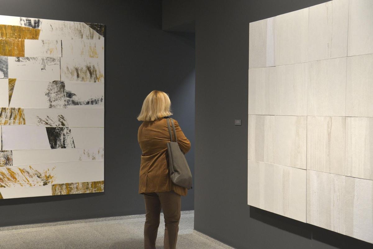 Una mujer contempla uno de los cuadros.