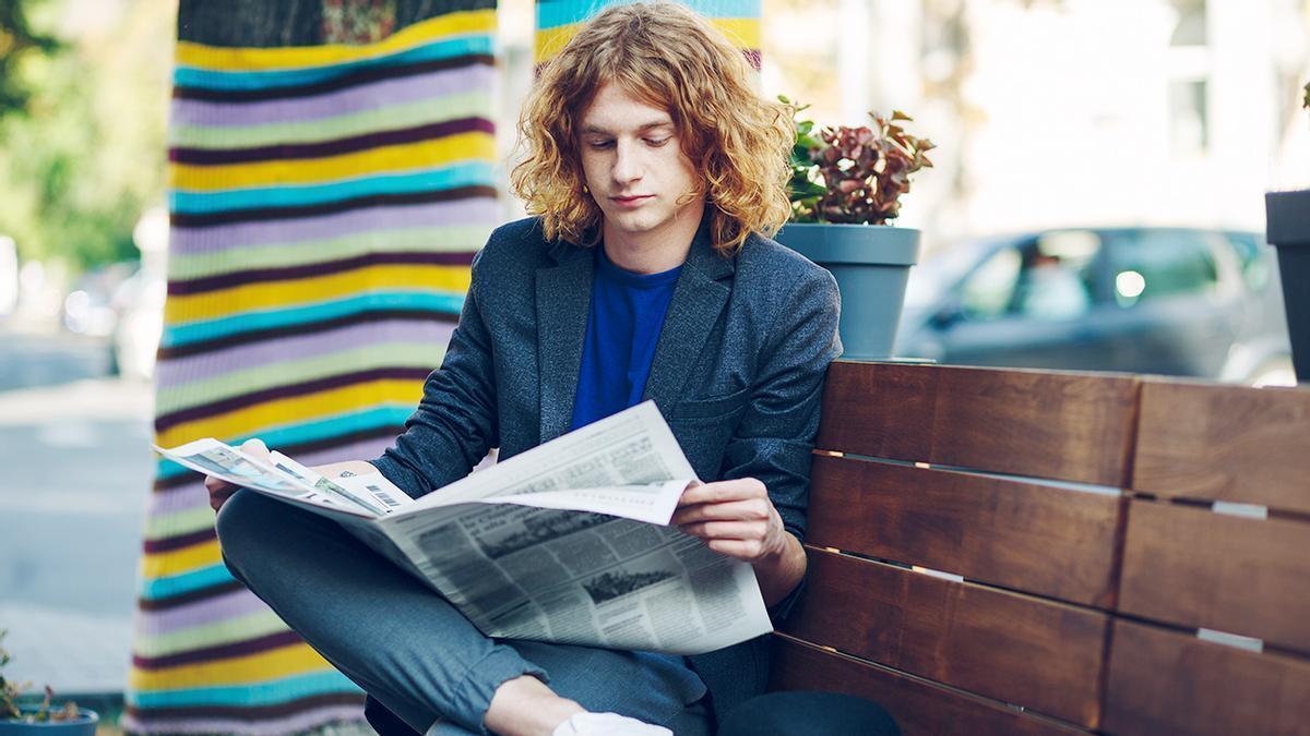 Un joven leyendo la prensa.