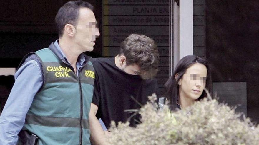 El asesino confeso, Patrick Nogueira, escoltado por dos agentes tras entregarse a las autoridades. // Efe