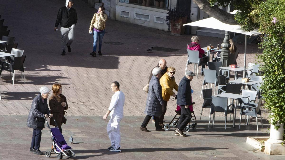 Un grup de persones majors passeja per la plaça Major d’Alzira, en una imatge recent