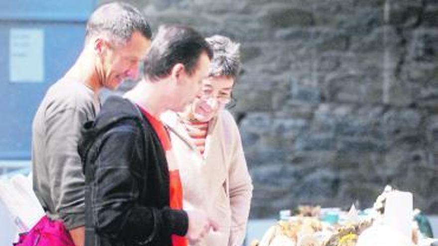 A la izquierda, visitantes en la exposición de setas en Mieres. A la derecha, dos comensales disfrutan del pitu de caleya en un restaurante de Rioseco.