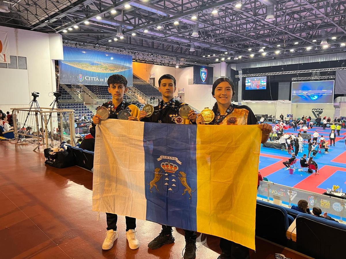 Julio, Pablo y Leisi posan con la bandera de Canarias y la medalla lograda