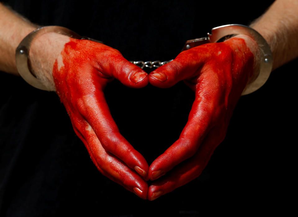 A protester wears handcuffs on his bloodstained ...