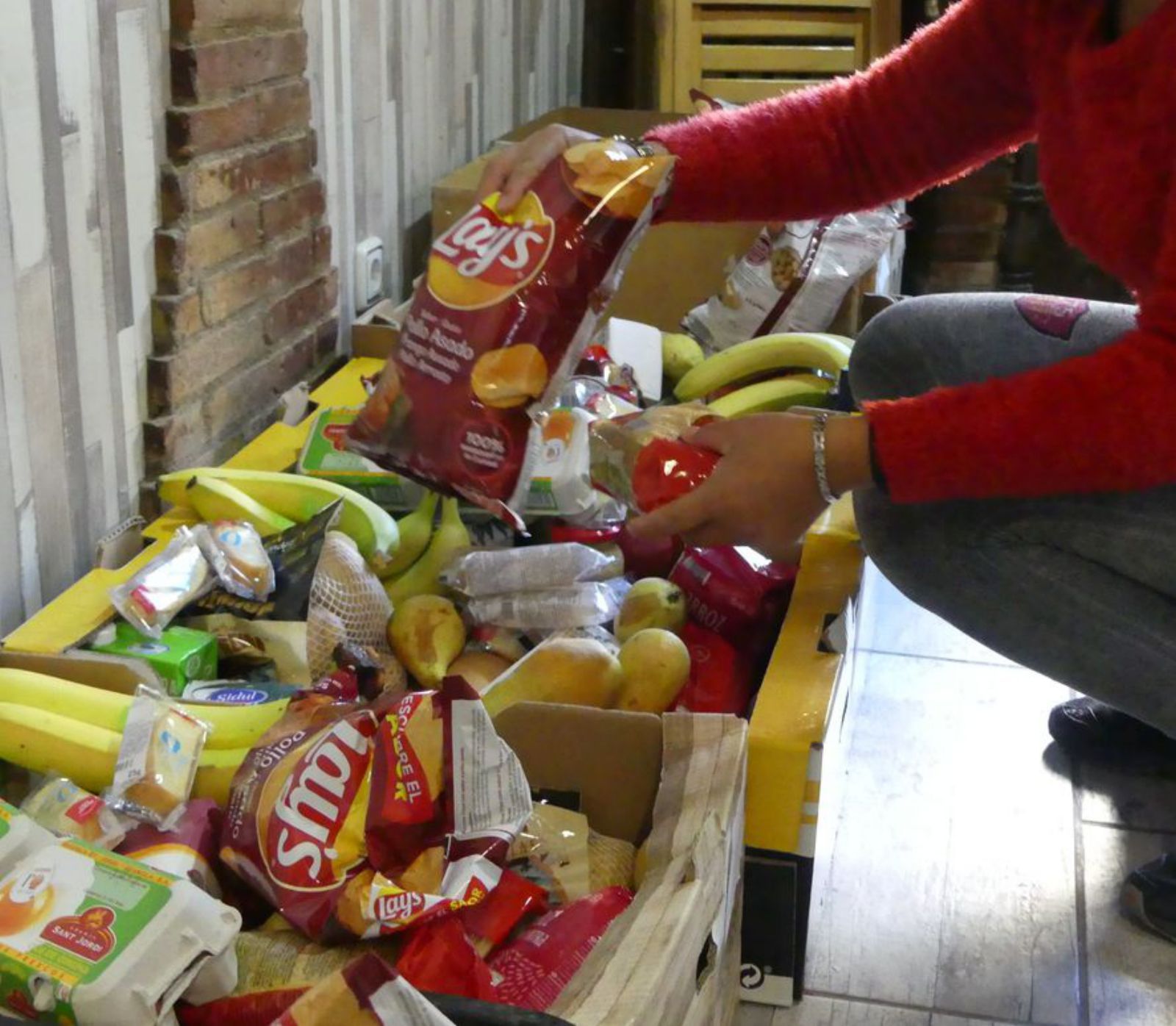 Una voluntària preparant una caixa d’aliments