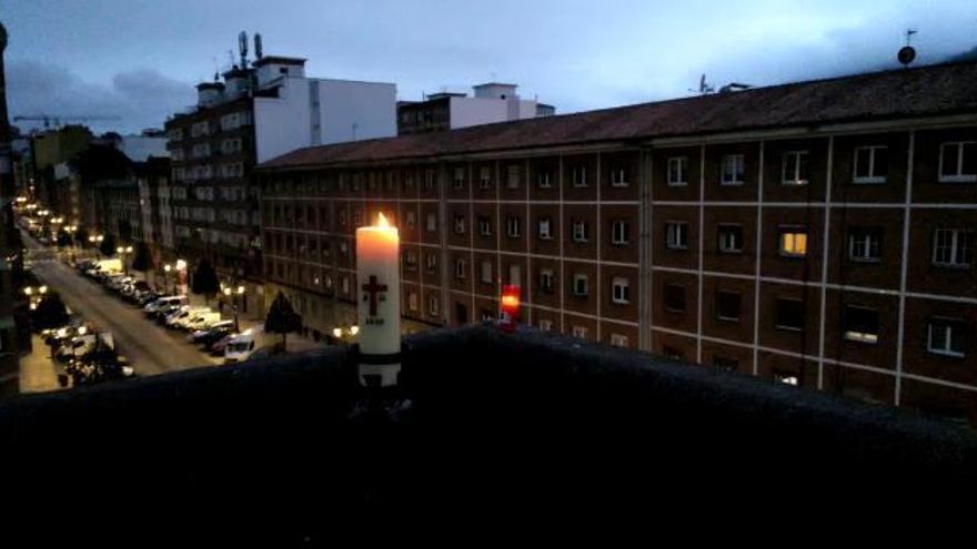 Velas y cirio pascual encendido en la azotea de la iglesia de San Francisco Javier de la Tenderina, en Oviedo