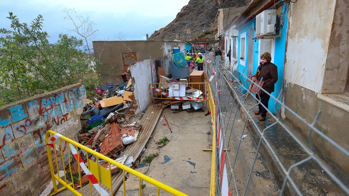 Enorme boquete abierto en la vía tras la caída de un muro, vallado ayer por los operarios.