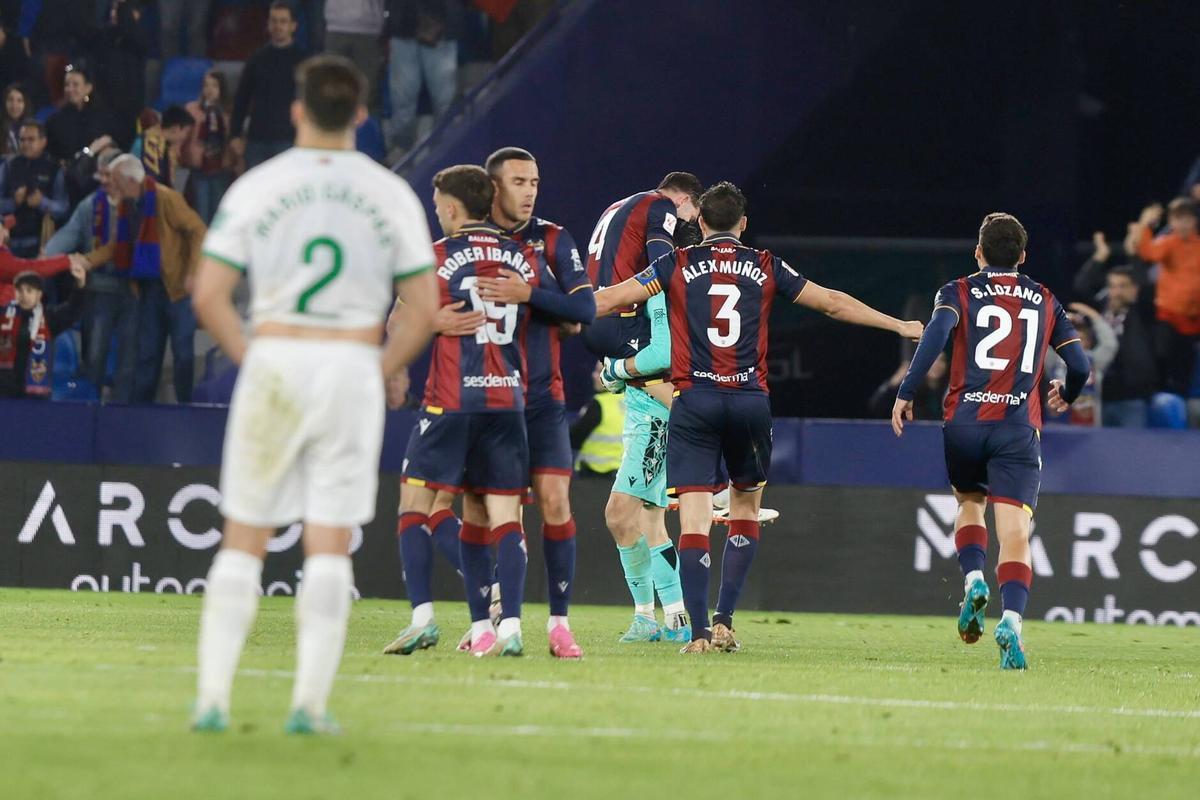 Mario Gaspar decepcionado al final del partido, mientras los jugadores del Levante celebran la victoria