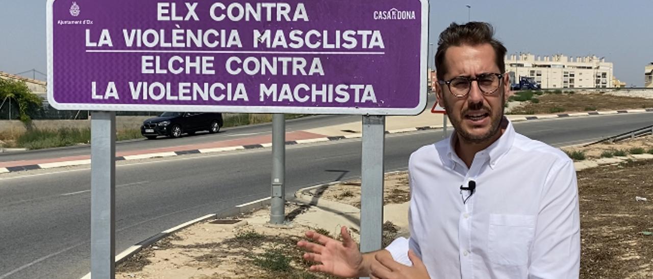 Sergio Rodríguez junto a uno de los carteles morados contra la violencia machista en Elche