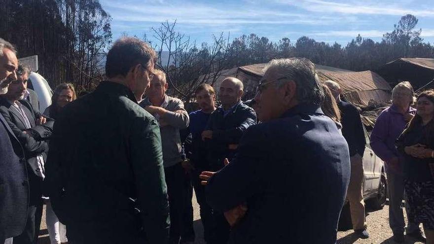 Feijóo (de espaldas) en una visita a cuatro familias de As Neves que perdieron sus casas en los incendios.