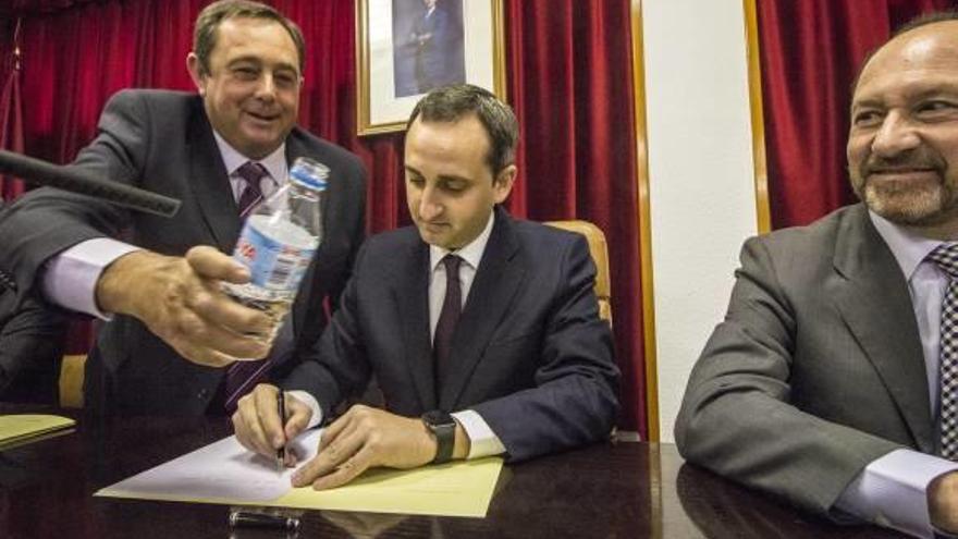 El juez de Aguas de Orihuela, Manuel Larrosa, llena el vaso al presidente César Sánchez, ayer.