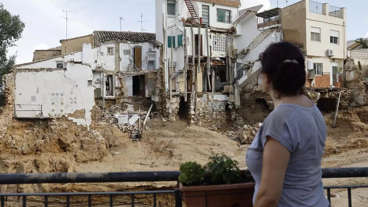 Una mujer mira las viviendas destrozadas por la dana en Chiva.