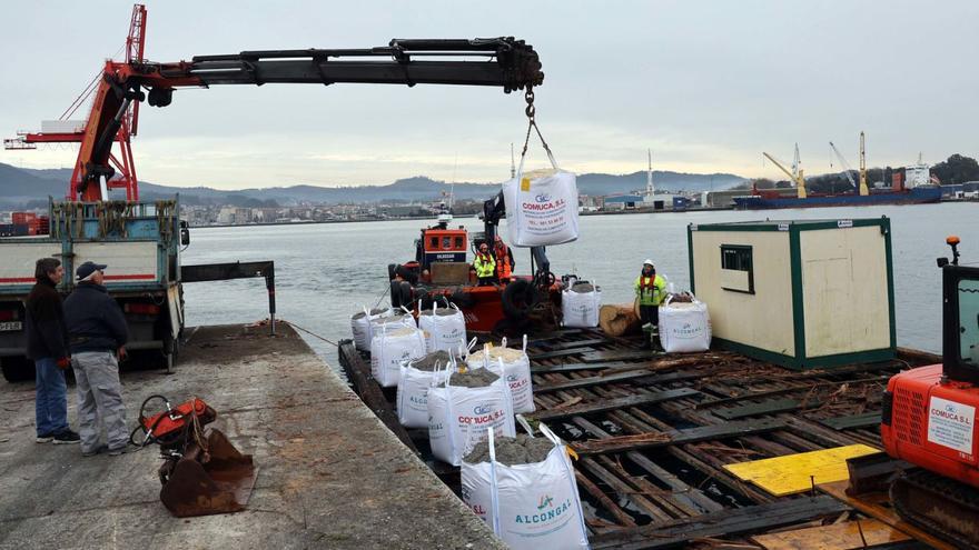 El material de obra para restaurar la capilla de Cortegada viaja a bordo de una batea