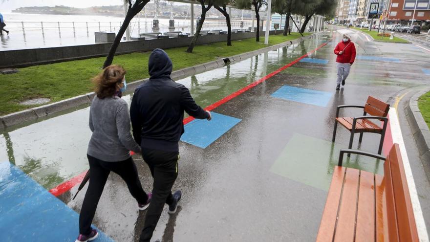 Paseantes en el Muro un día de lluvia.