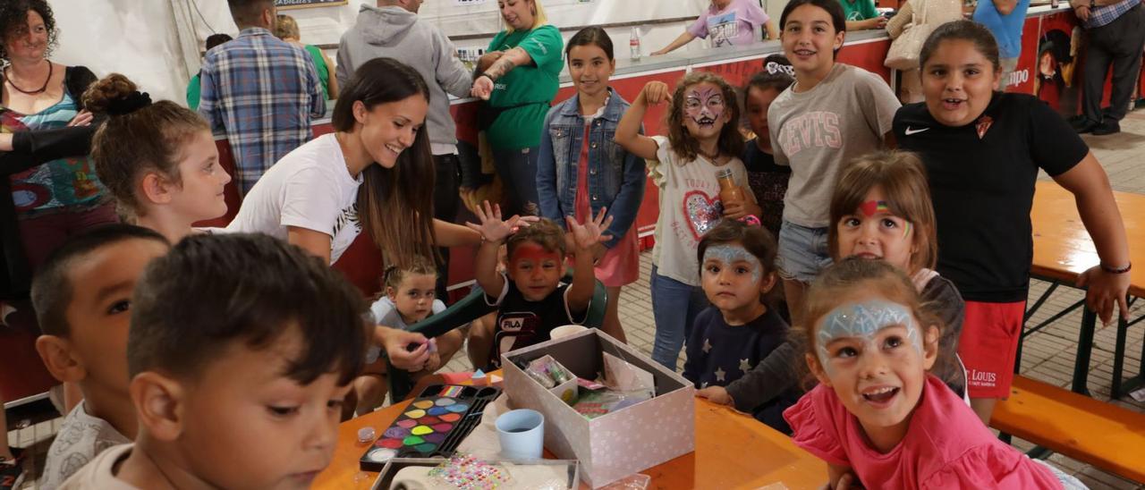 Varios niños, ayer, participando en la actividad del pintacaras en el barrio de Pescadores. | Juan Plaza |  J. PLAZA / M. LEÓN