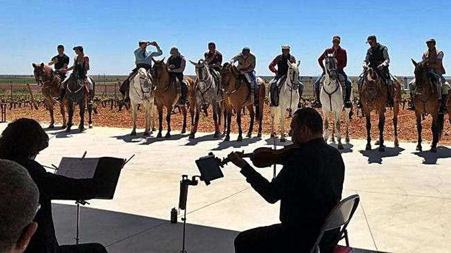 Caballos y jinetes siguen atentos a las notas musicales del concierto.