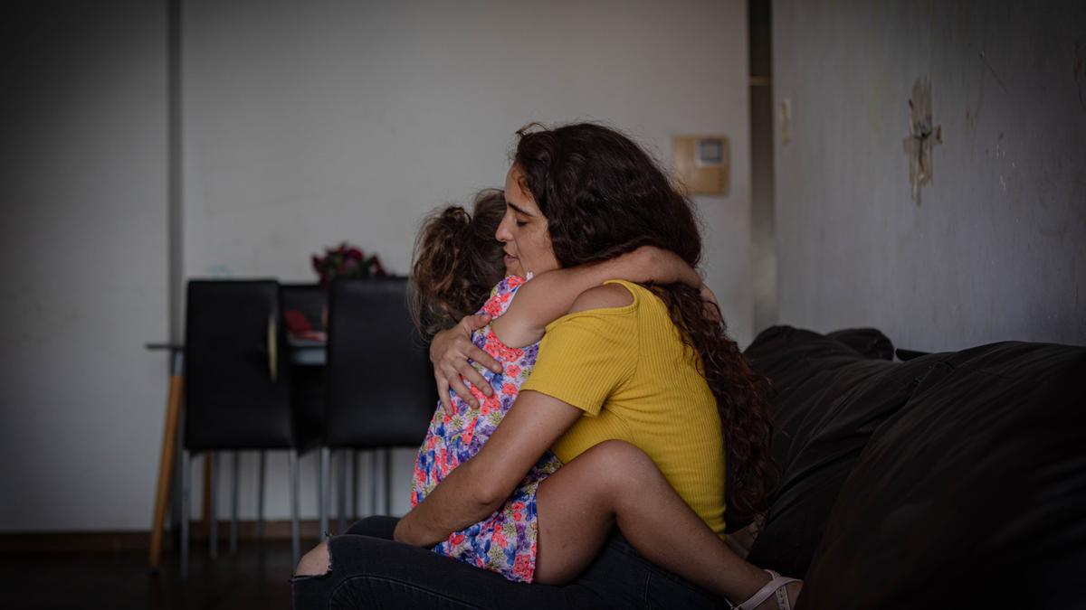 Tamara abrazando a su hija en el piso del barrio del Cabanyal.