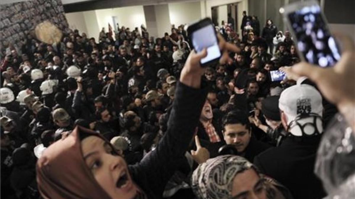 Un grupo de periodistas reaccionan ante el asalto de los antidisturbios en al sede del diario 'Zanan', es Estambul.