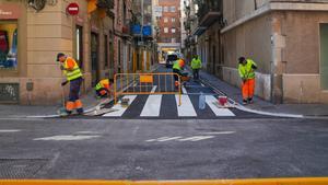 Un equipo de operarios realiza mejoras de la calzada en Barcelona.