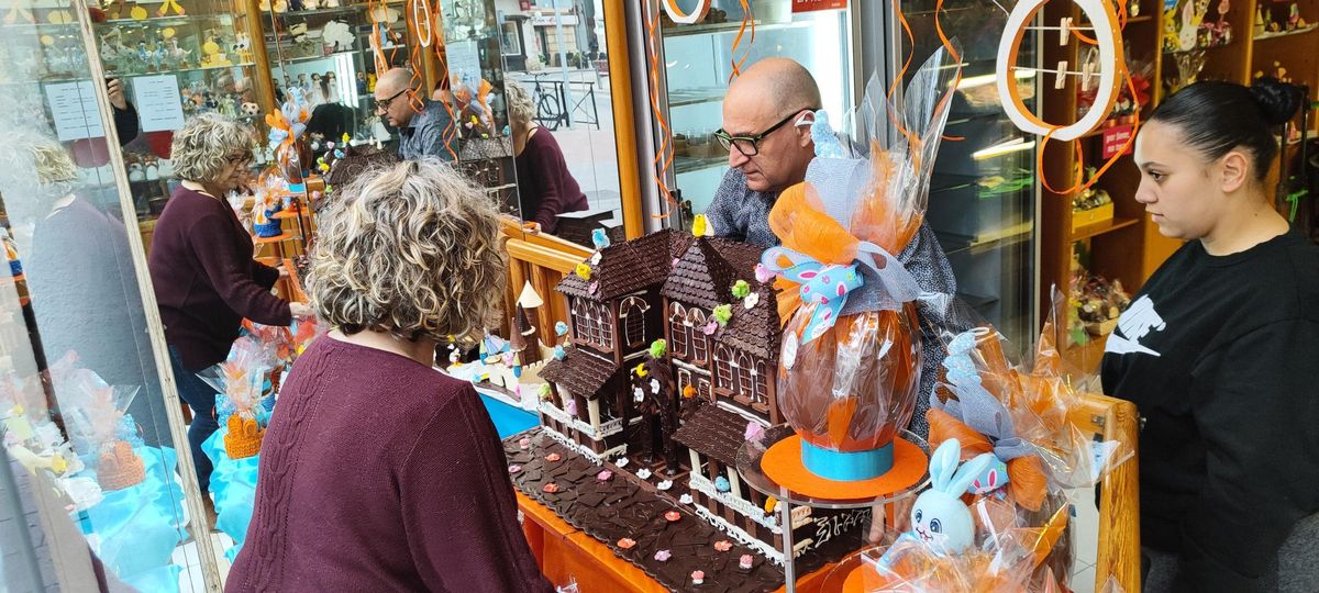 El pastelero y su mujer colocan la mona de este año en el escaparate de su negocio, Pastisseria Macip.