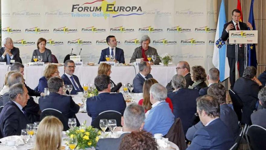 Caballero interviene en Los Escudos ante Elena Espinosa (2ª izq.)y, en la mesa principal, parte de su equipo, los presidentes de CEG, CEP y Cámara y representantes sindicales. // M. G. Brea