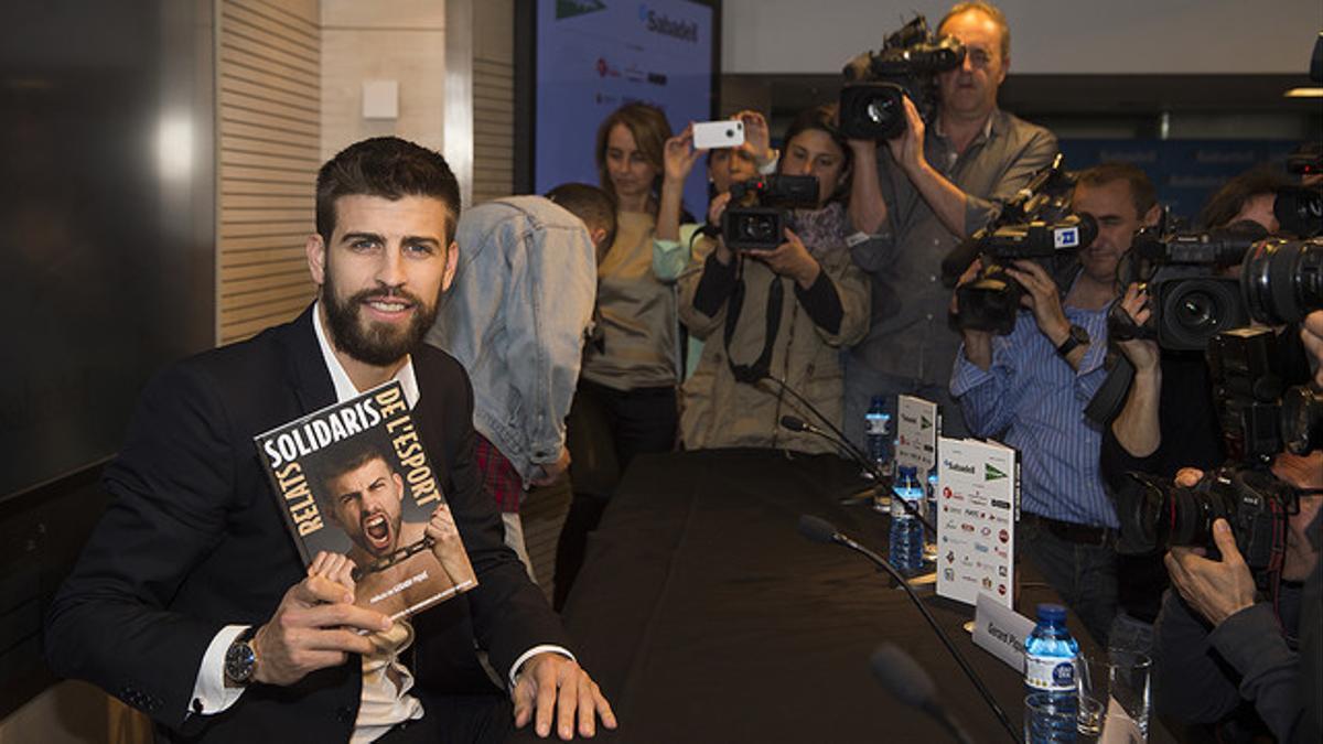 Gerard Piqué, con un ejemplar del libro 'Relatos solidarios del deporte'