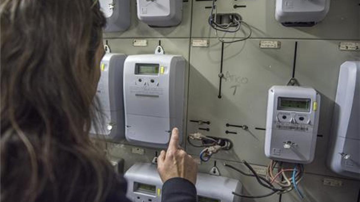 Una mujer mira un contador de luz