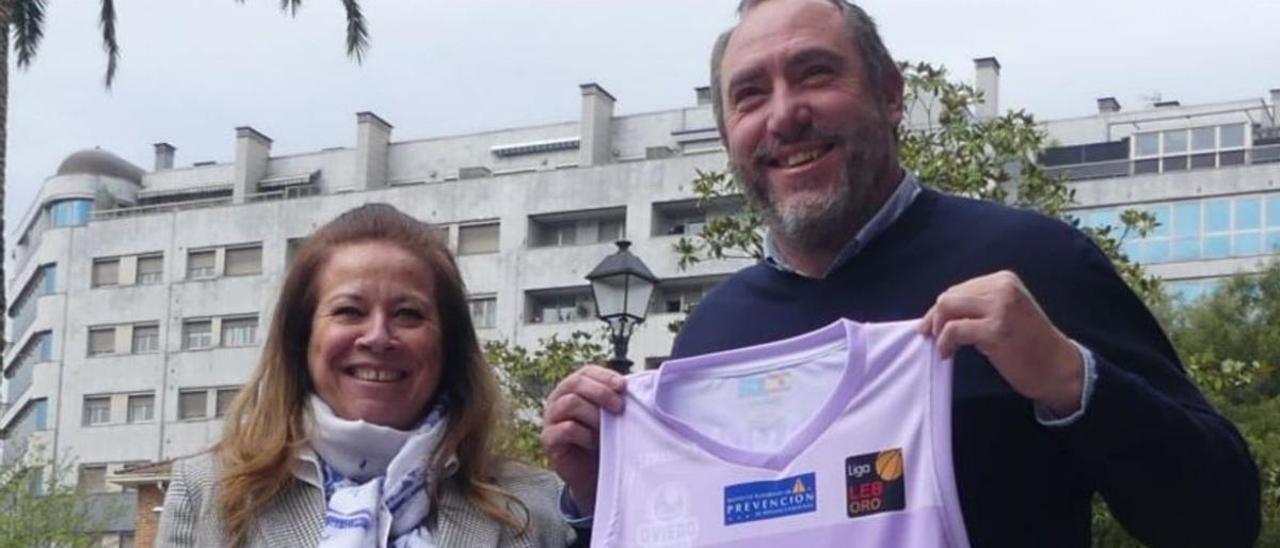 Myriam Hernández y Héctor Galán, ayer en Pumarín, con uno de los carteles promocionales y la camiseta conmemorativa. | OCB