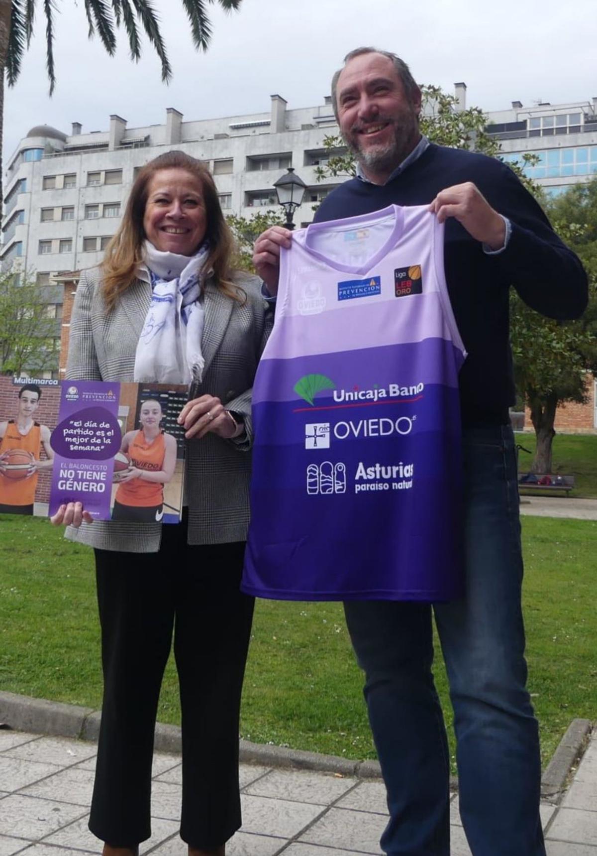 Myriam Hernández y Héctor Galán, ayer en Pumarín, con uno de los carteles promocionales y la camiseta conmemorativa. | OCB