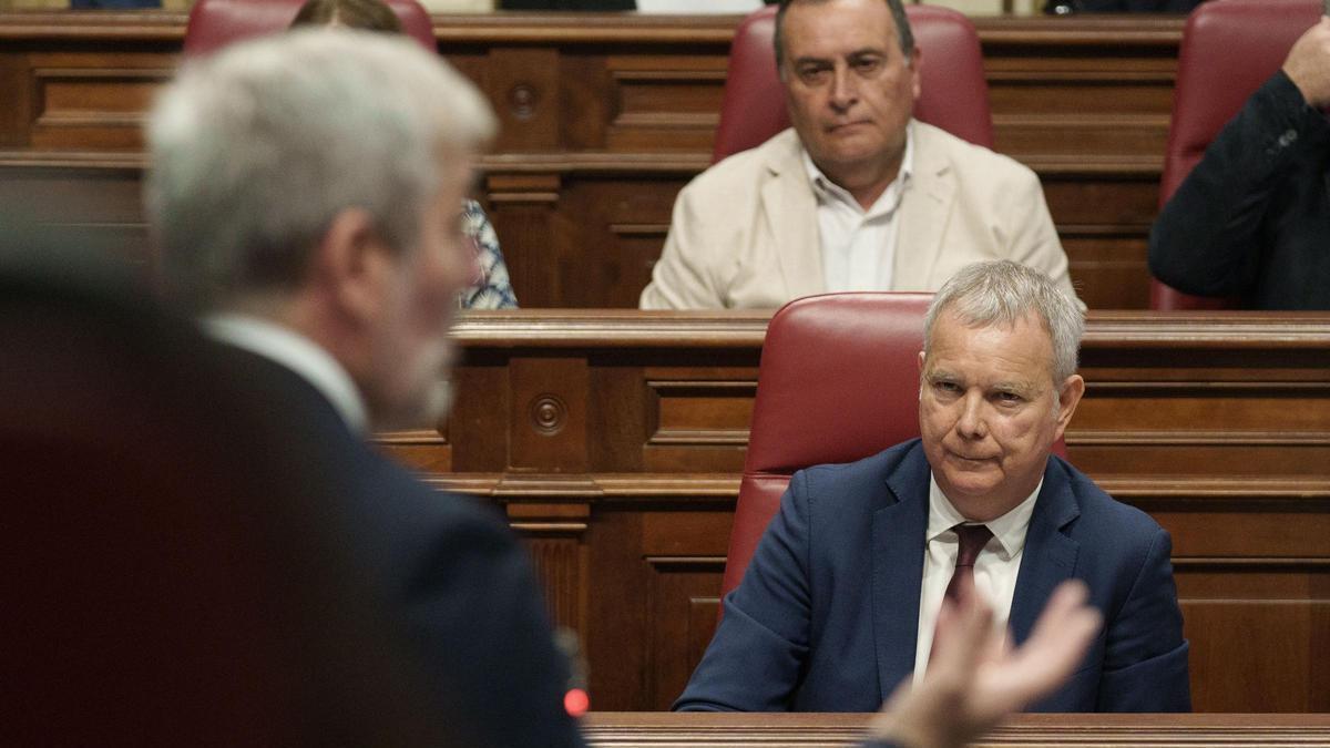 El socialista Sebastián Franquis observa una intervención del presidente Fernando Clavijo en el último pleno del Parlamento.