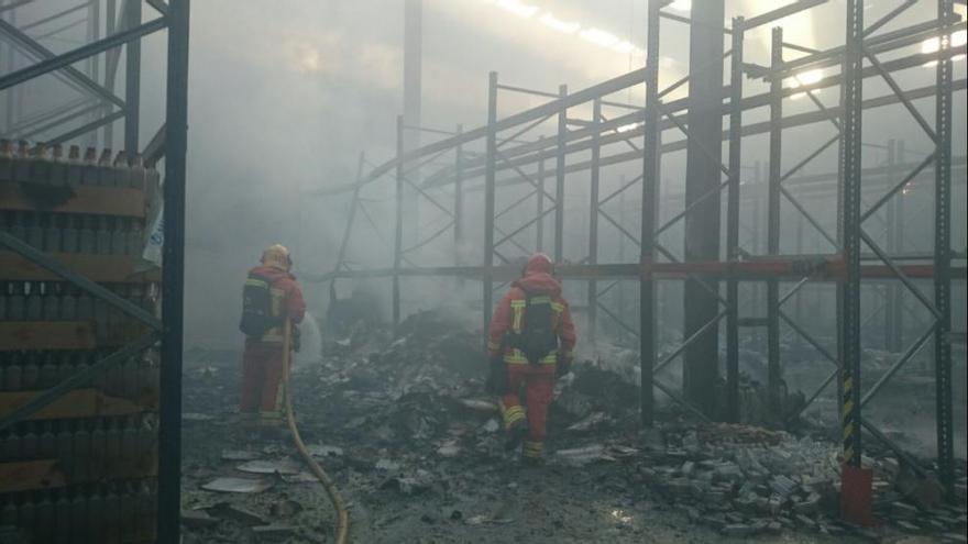 Los bomberos, dentro de la fábrica incendiada en Algemesí.