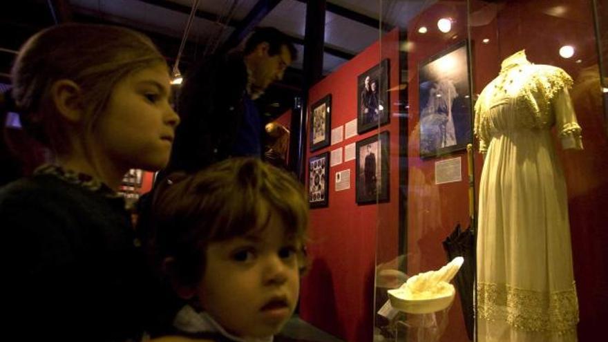 Un hombre y dos niños contemplan objetos relacionados con el «Titanic» en el Marítimo.
