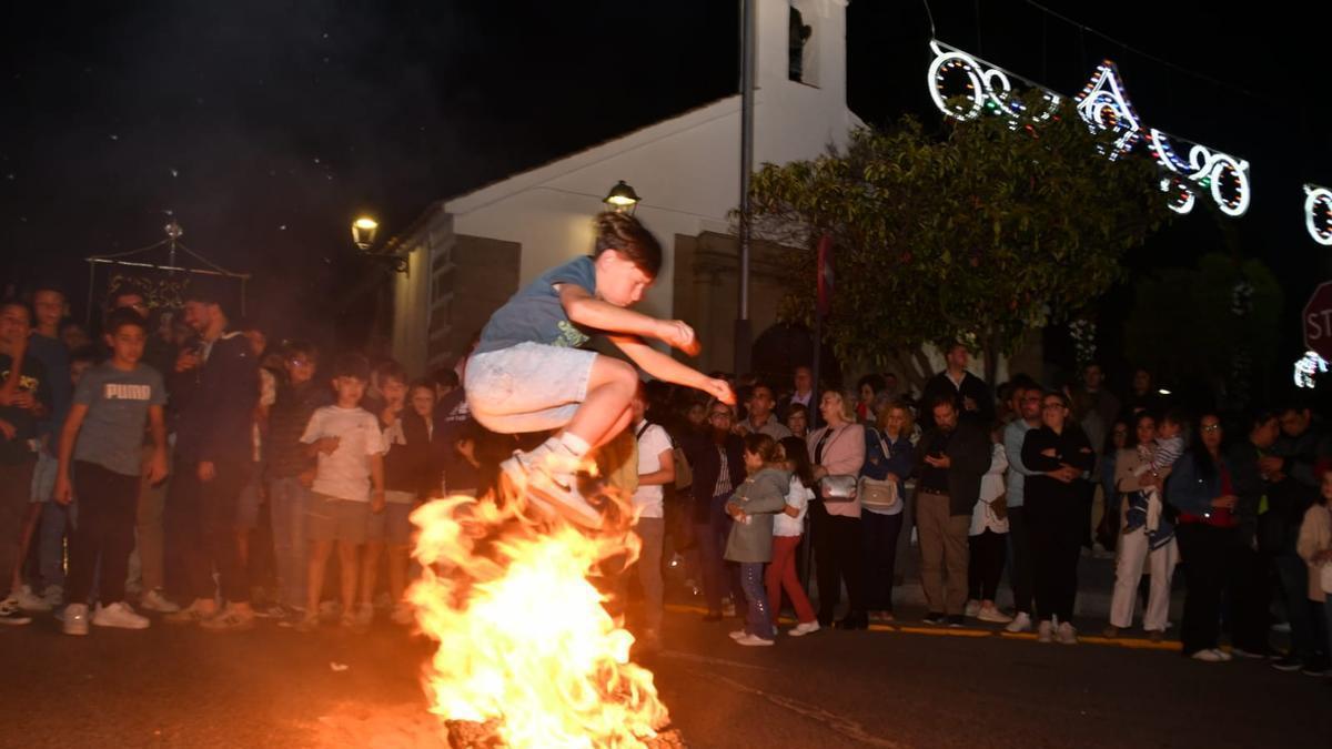 Un joven salta una hoguera durante la quema del corcho en Pozoblanco.