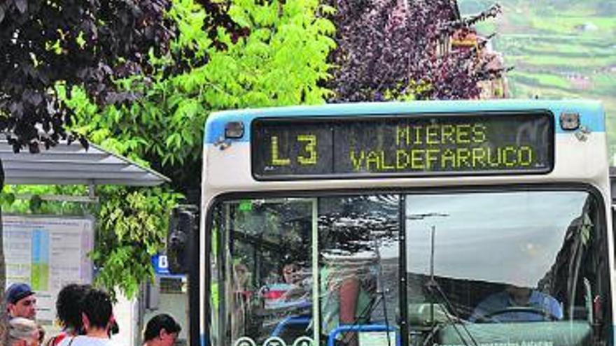 Viajeros subiendo a un autobús de la empresa municipal de transportes de Mieres.