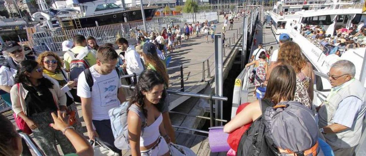 Turistas subiendo a uno de los barcos que cubren la ruta entre Vigo y Cíes. // FdeV