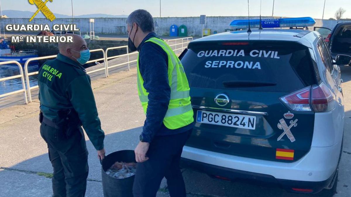 Dos agentes, con el pulpo incautado.   | // FDV