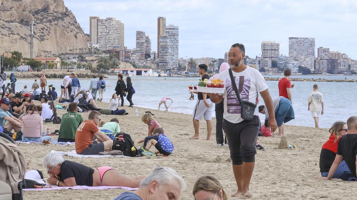 Un vendedor ambulante ilegal de bebidas en la playa del Postiguet en imagen reciente.