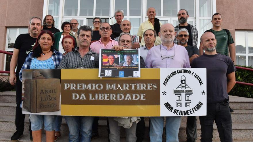 Participantes, ayer, en el acto de entrega del premio Mártires da Liberdade a Francisco Martínez López ‘Quico’ portan una fotografía del homenajeado, que no pudo asistir a la ceremonia.   | // VÍCTOR ECHAVE