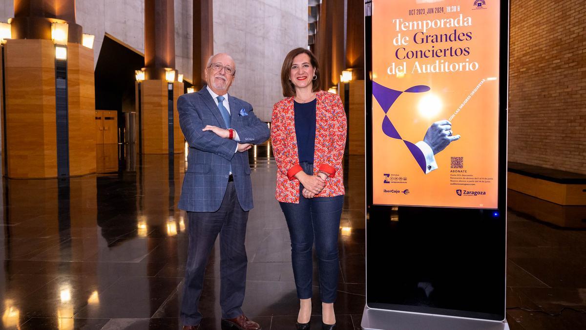 Miguel Ángel Tapia y Sara Fernández junto al cartel de los Grandes Conciertos de la próxima temporada.