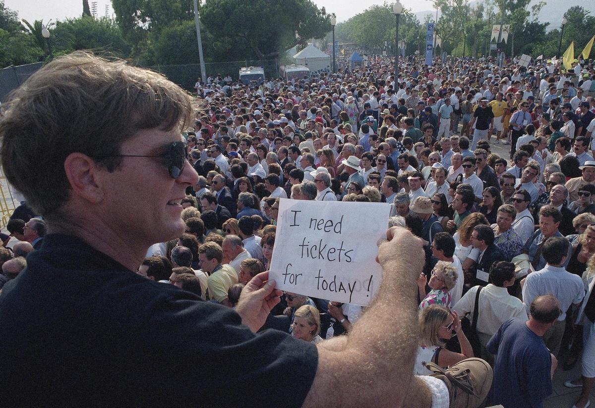 Un hombre muestra un cartel en el que puede leerse Necesito entradas para hoy, en las inmediaciones del Estadio Olímpico de Montjuïc.