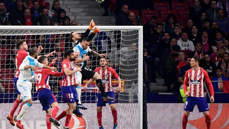 El portero Oblak despeja el balón mientras Guilherme y Sidnei saltan al remate.