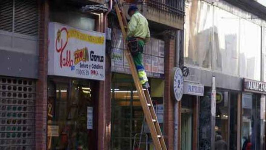 Un operario instala fibra óptica en la fachada de un edificio en la calle La Rúa. /