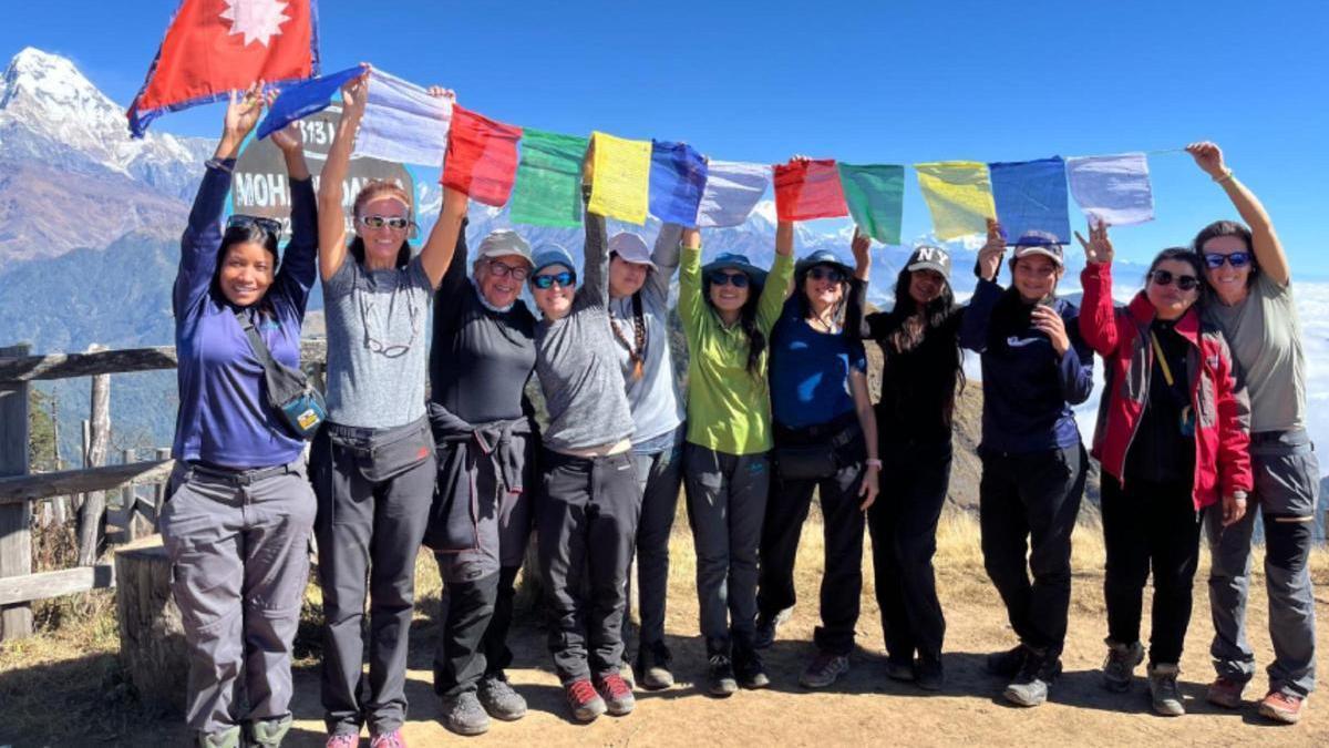 Foto de un grupo de montañeras durante un viaje de trekking en el Himalaya, junto a las guías locales.