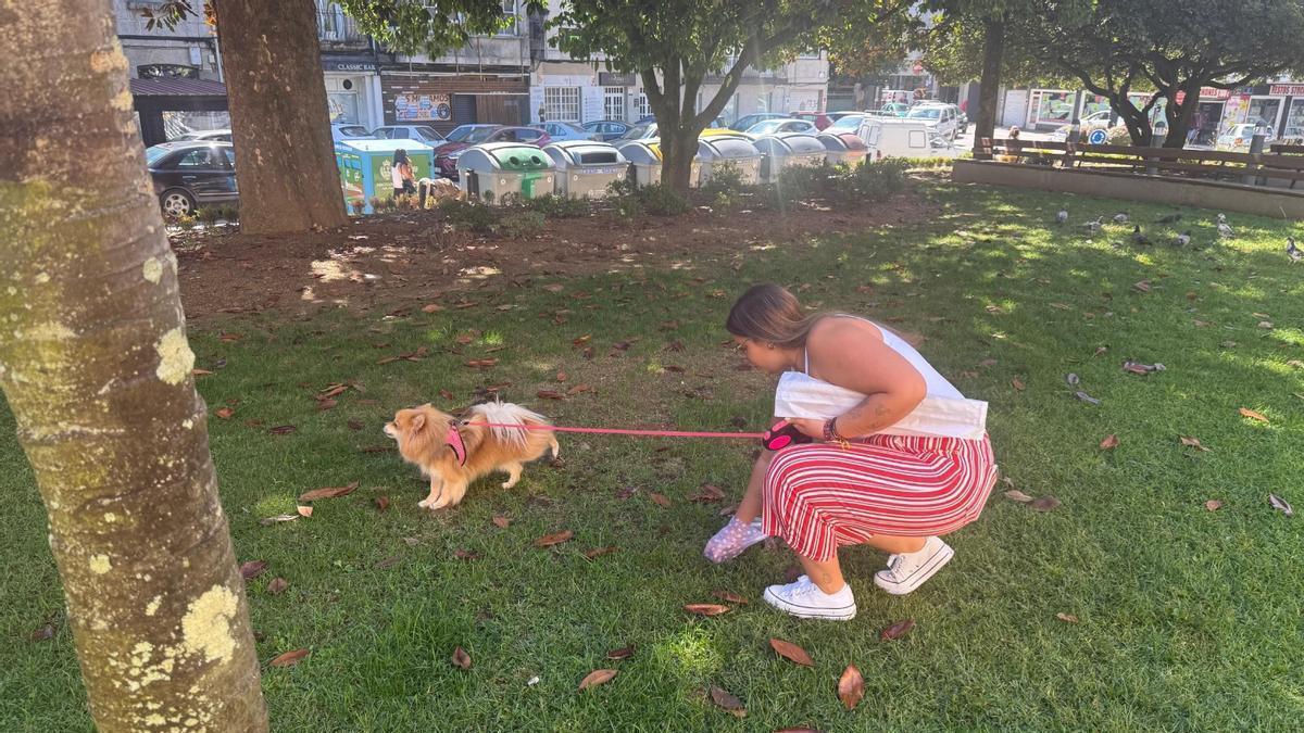 Una mujer recoge los excrementos de su perro.