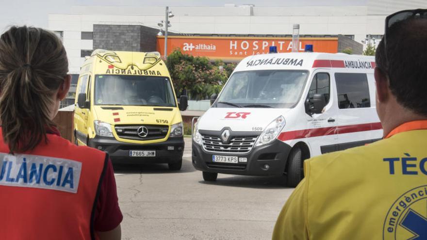 Dos tècnics sanitaris observen les ambulàncies davant de l&#039;Hospital de Sant Joan de Déu de Manresa