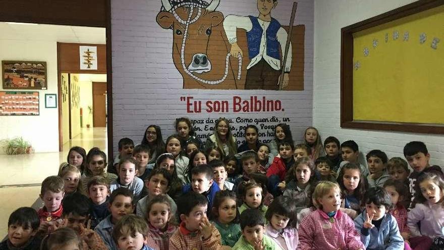 En la imagen superior, los alumnos del centro posan ante un mural sobre el libro más leído de Neira Vilas. A la izquierda, mensajes en las escaleras.