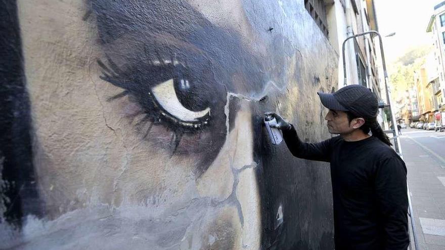 El artista, trabajando en uno de sus murales ubicado en la fachada del colegio Liceo-Aniceto Sela.