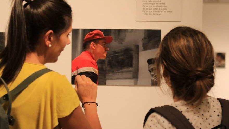 Varias jóvenes observan una de las fotografías exhibidas.