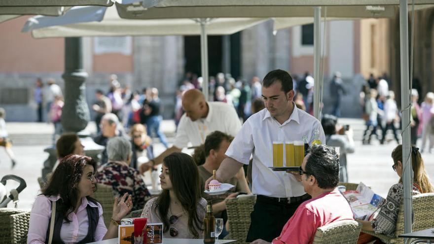 Varias personas toman un refrigerio en una terraza de Valencia.