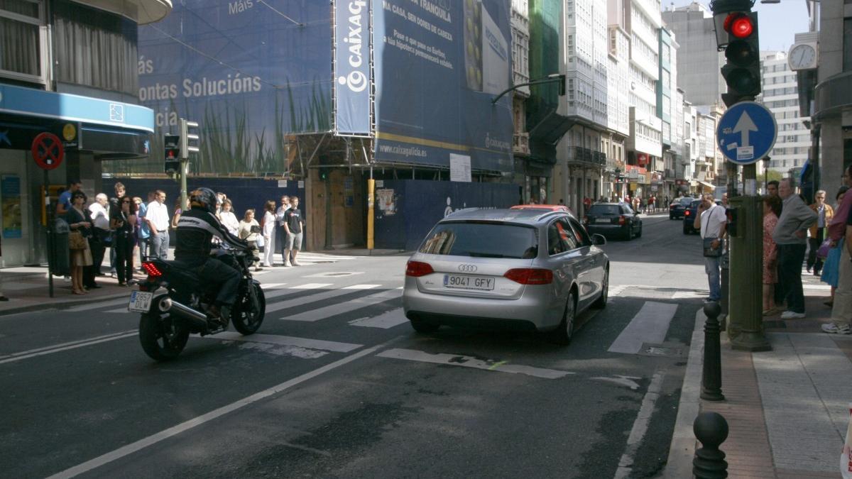 Moto parada en un semáforo en la calle San Andrés de A Coruña