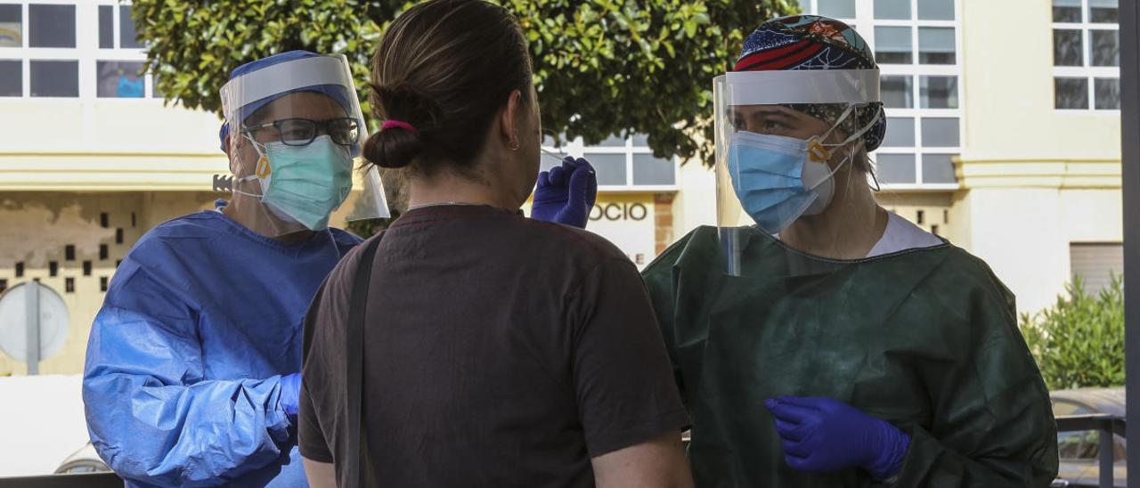 Sanitarios tomando una muestra para una prueba PCR a la puerta de un centro de salud de Elche.